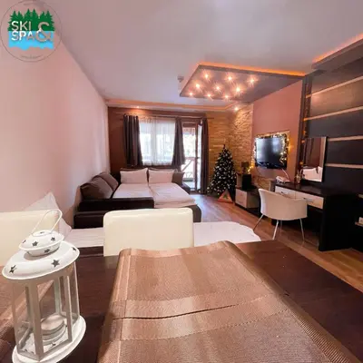 a living room with a couch and a table and a living room with a couch at SKI & SPA Apartment in ZONED in Kopaonik