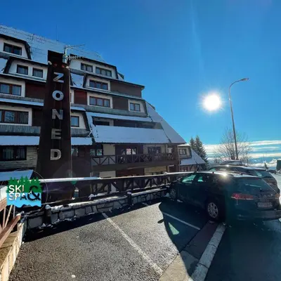 a car parked in a parking lot in front of a building at SKI & SPA Apartment in ZONED in Kopaonik