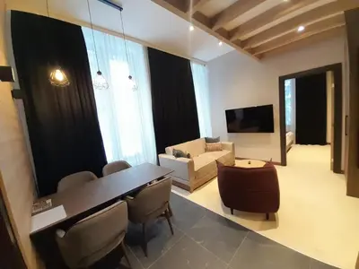 a living room with a table and chairs and a couch at Woodside Kopaonik AAC in Raška