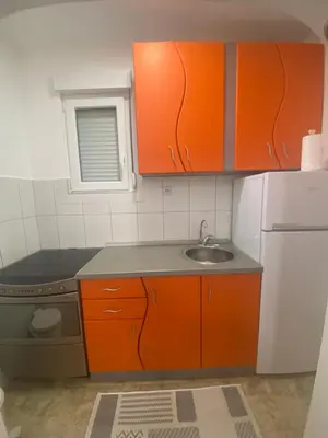 a small kitchen with orange cabinets and a sink at Eleni in Vrnjačka Banja