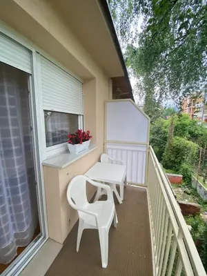 a balcony with a table and chairs and a window at Eleni in Vrnjačka Banja