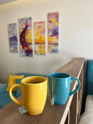 two yellow and blue cups sitting on a wooden table at Milmari Golden N LUX 62 in Kopaonik