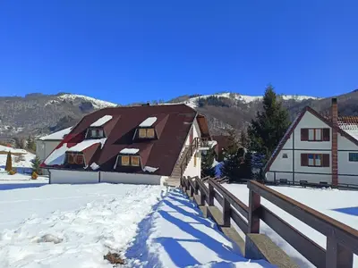a house in the snow with a wooden fence at Apartmani LEON Brzeće/Apartmens LEON Brzece in Brzeće