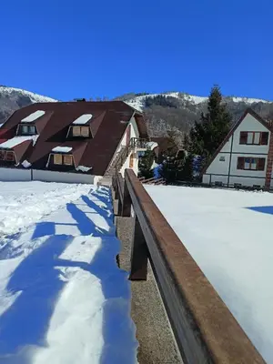 a snow covered roof of a house with buildings at Apartmani LEON Brzeće/Apartmens LEON Brzece in Brzeće