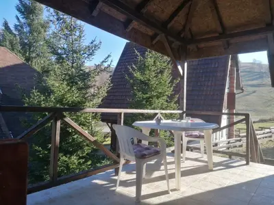 a patio with a table and chairs on a balcony at Apartmani LEON Brzeće/Apartmens LEON Brzece in Brzeće