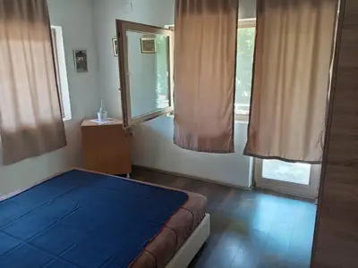 a bedroom with a blue bed and two windows at Oko Jastrepca in Veliko Krušince