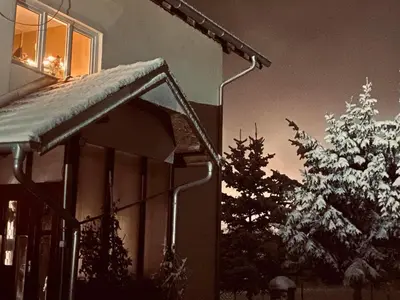 a house with snow on the roof and a tree at Vila Vanilla in Donji Striževac