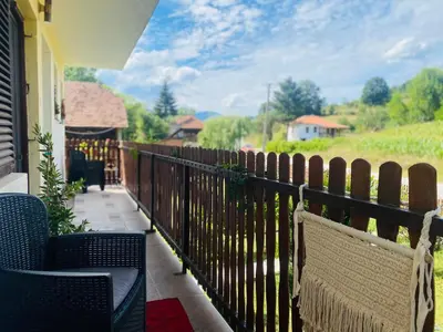 a balcony with two chairs and a fence with a view at Vila Vanilla in Donji Striževac