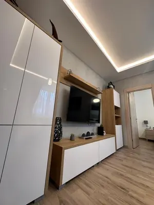 a living room with a tv and a white cabinet at Apartman 3 - Vila Montana in Kopaonik