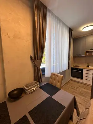 a living room with a table and a kitchen at Apartman 3 - Vila Montana in Kopaonik