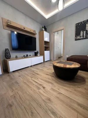a living room with a large couch and a large tv at Apartman 3 - Vila Montana in Kopaonik