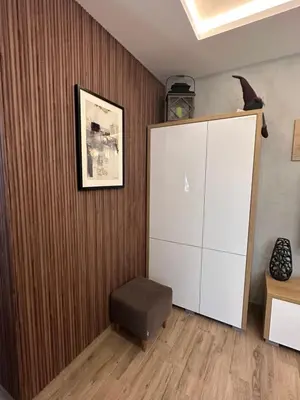 a room with a white cabinet and a chair at Apartman 3 - Vila Montana in Kopaonik