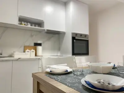 a kitchen with a table with bowls and plates on it at Apartmani ANA - Kopaonik, Treska in Kopaonik