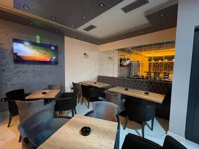 a restaurant with wooden tables and chairs and a tv on the wall at Apartmani ANA - Kopaonik, Treska in Kopaonik