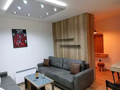 a living room with a couch and a table at Apartmani ANA - Kopaonik, Treska in Kopaonik