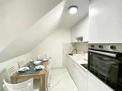 a kitchen with a wooden table and white cabinets at Apartmani ANA - Kopaonik, Treska in Kopaonik