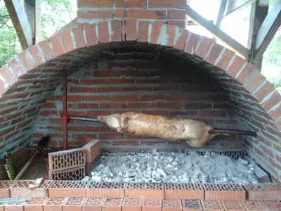 a brick oven with a large animal cooking at Vila Kula in Crni Vrh