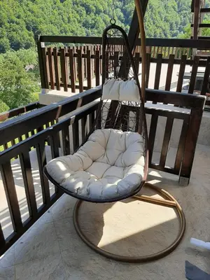 a swinging chair on a balcony with a view at Vila Kula in Crni Vrh