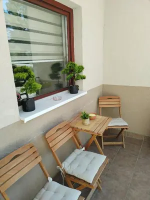 a balcony with two chairs and a table and a window at ROSA in Vrnjačka Banja