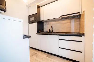 a kitchen with white cabinets and a sink at Vision apartmani Vrnjačka Banja in Vrnjačka Banja
