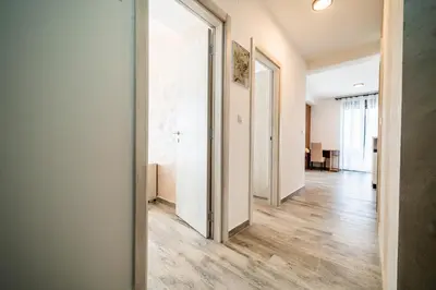 an open hallway with wood floors and an open door at Vision apartmani Vrnjačka Banja in Vrnjačka Banja