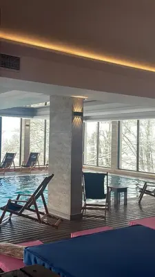 a swimming pool with chairs and a table in a building at N Lux 81 - Milmari Resort in Kopaonik