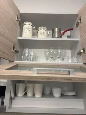 a kitchen shelf with glasses and cups on it at Vila Kopaonik Apartmani Milenkovic in Kopaonik