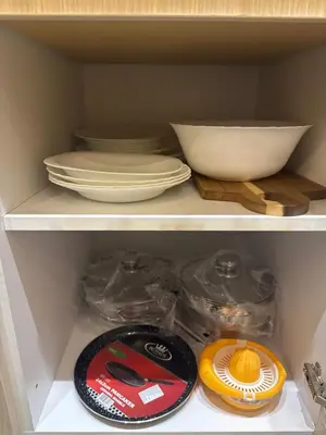 a shelf with plates and bowls and a bowl at Vila Kopaonik Apartmani Milenkovic in Kopaonik