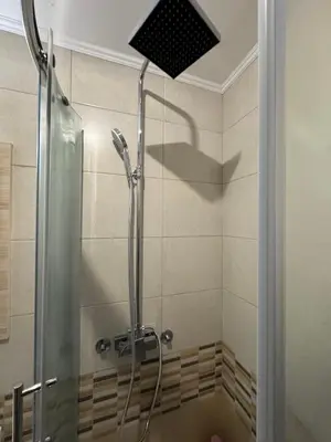 a shower with a shower head in a bathroom at Vila Kopaonik Apartmani Milenkovic in Kopaonik