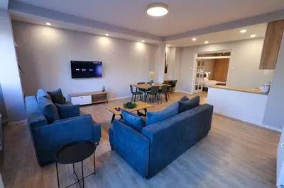 a living room with two blue couches and a table at Heart of Niš Lux in Niš