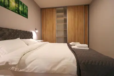 a bedroom with a large bed with two towels on it at Heart of Niš Lux in Niš