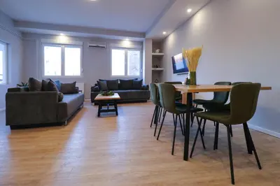 a living room with a table and chairs and a couch at Heart of Niš Lux in Niš