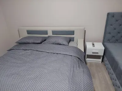 a bedroom with a bed with a blue comforter at Rajna in Pirot