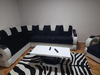 a living room with a black and white couch and a table at Rajna in Pirot