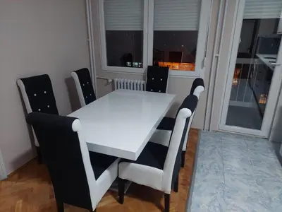 a white table and chairs in a room with a window at Rajna in Pirot