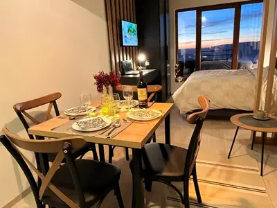 a dining room table with a bottle of wine and chairs at Milmari resort Nlux21 in Kopaonik