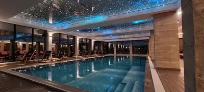 a swimming pool in a building with a star ceiling at Milmari resort Nlux21 in Kopaonik