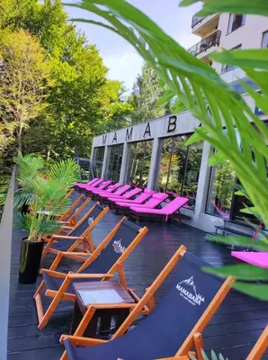 a row of lounge chairs and tables on a patio at Milmari resort Nlux21 in Kopaonik
