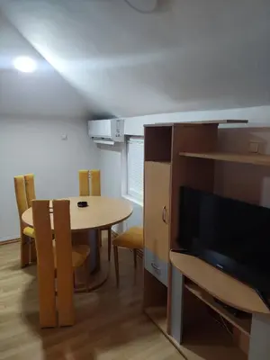 a room with a table and a television and a table and chairs at ASTRA in Pirot