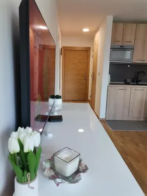a kitchen with a white counter with flowers on it at MDM Apartman Vrnjačka Banja in Vrnjačka Banja