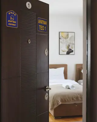 a door leading to a bedroom with a bed at Apartmani TEO in Prokuplje