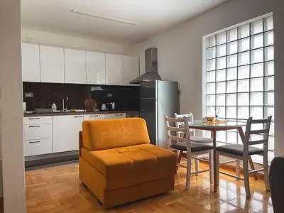 a kitchen with a table and a chair and a dining room at Apartmani TEO in Prokuplje