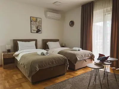 a bedroom with two beds and a window at Apartmani TEO in Prokuplje