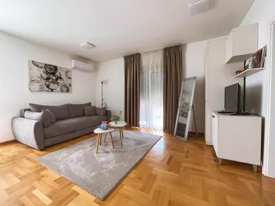 a living room with a couch and a television at Apartmani TEO in Prokuplje