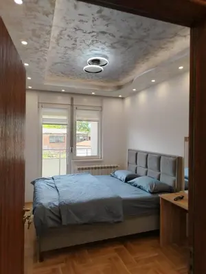 a bedroom with a bed with a ceiling at Apartman Branković Pirot-Zapadni Kej 58 in Pirot
