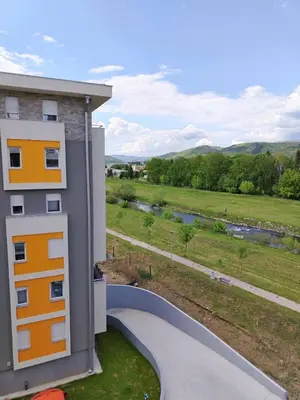 a building with a view of a field and a river at Apartman Branković Pirot-Zapadni Kej 58 in Pirot