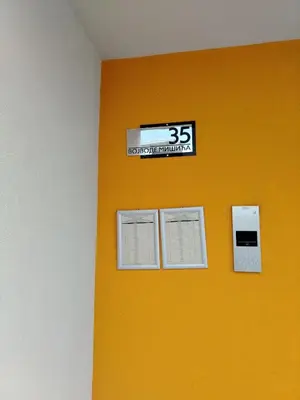 a yellow wall with a sign on it that reads laboratory technician at Apartman Branković Pirot-Zapadni Kej 58 in Pirot