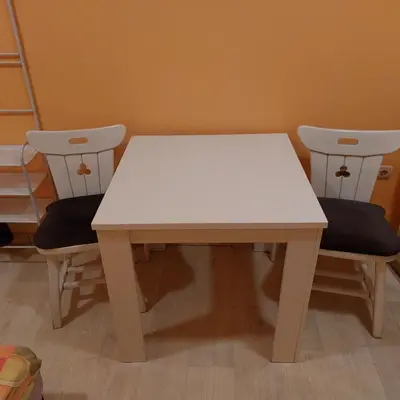 a white table and two chairs in a room at Soba Lara in Kruševac