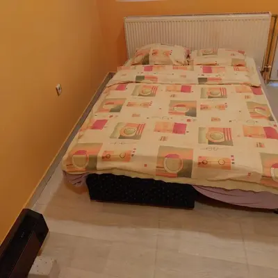 a bed with a comforter on it in a bedroom at Soba Lara in Kruševac