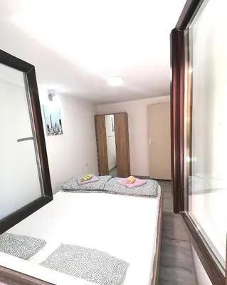 two beds in a room with a window at Apartman Mata in Soko Banja
